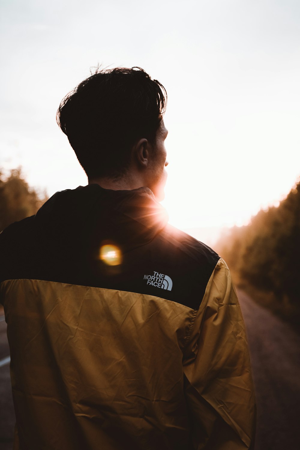 man in black and white adidas shirt standing during daytime