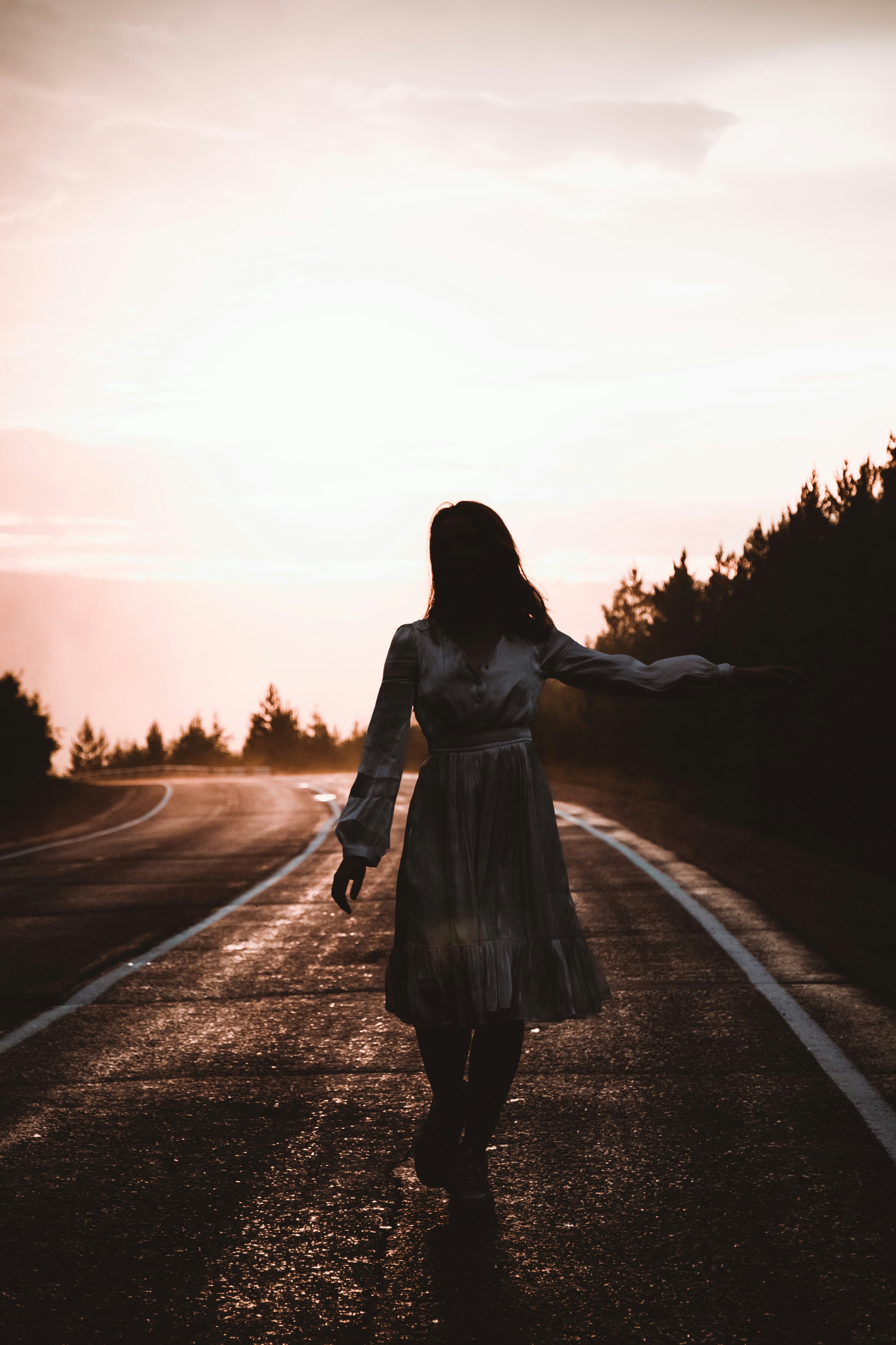 woman in white long sleeve dress standing on road during daytime
