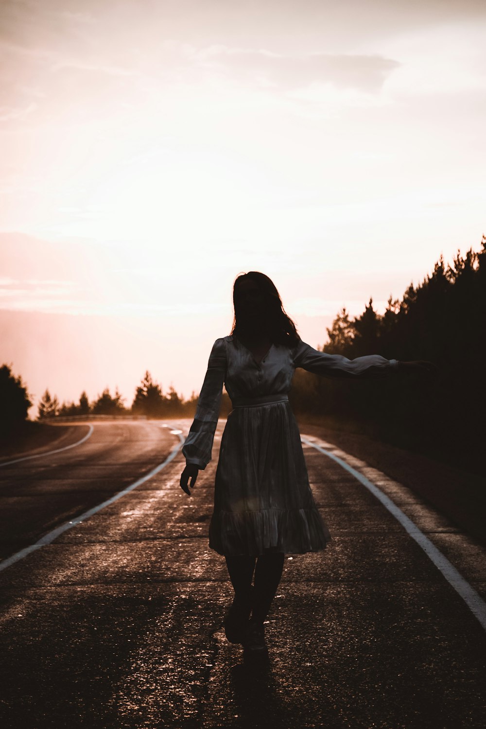 woman in white long sleeve dress standing on road during daytime