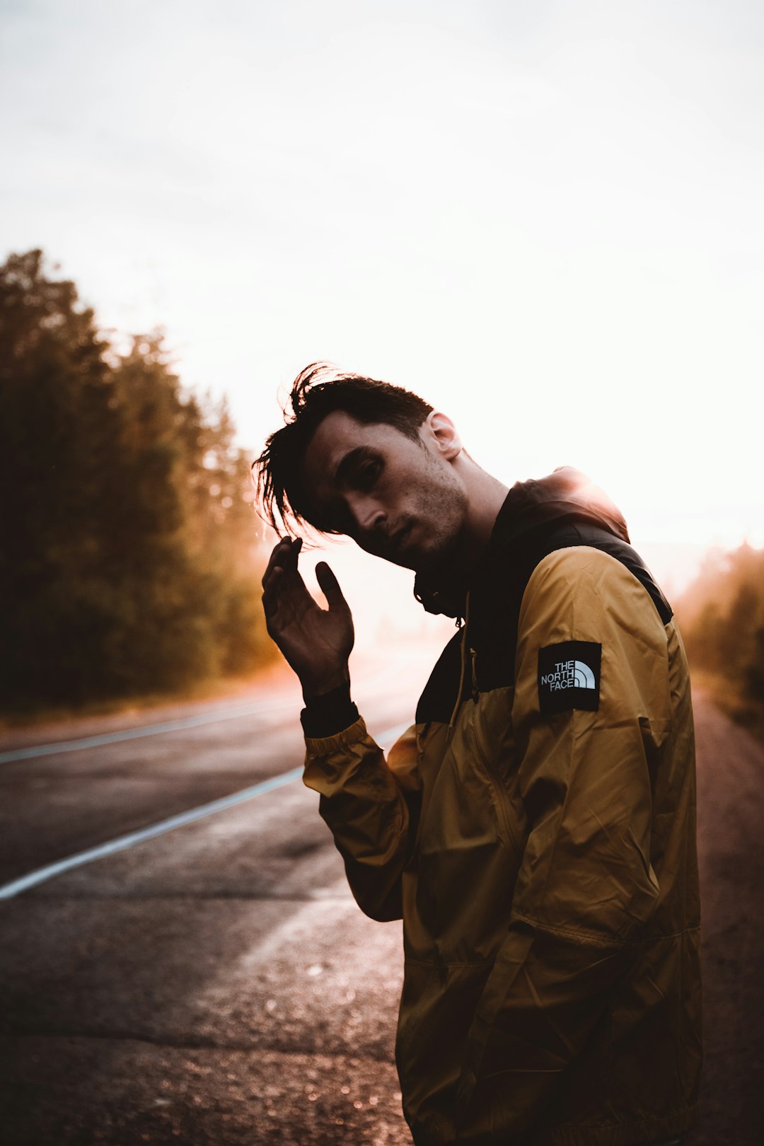 man in green jacket standing on road during daytime