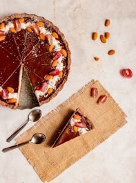 sliced pie on white ceramic plate beside stainless steel spoon and fork