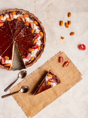 sliced pie on white ceramic plate beside stainless steel spoon and fork