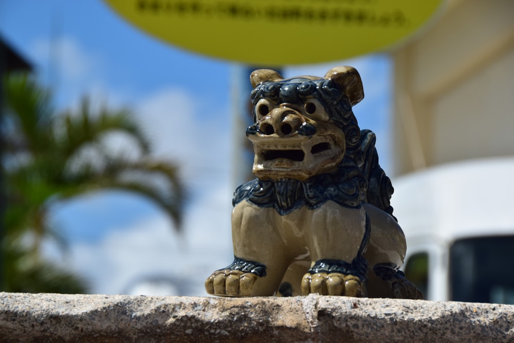 Statue de lion d’or sur surface en béton gris