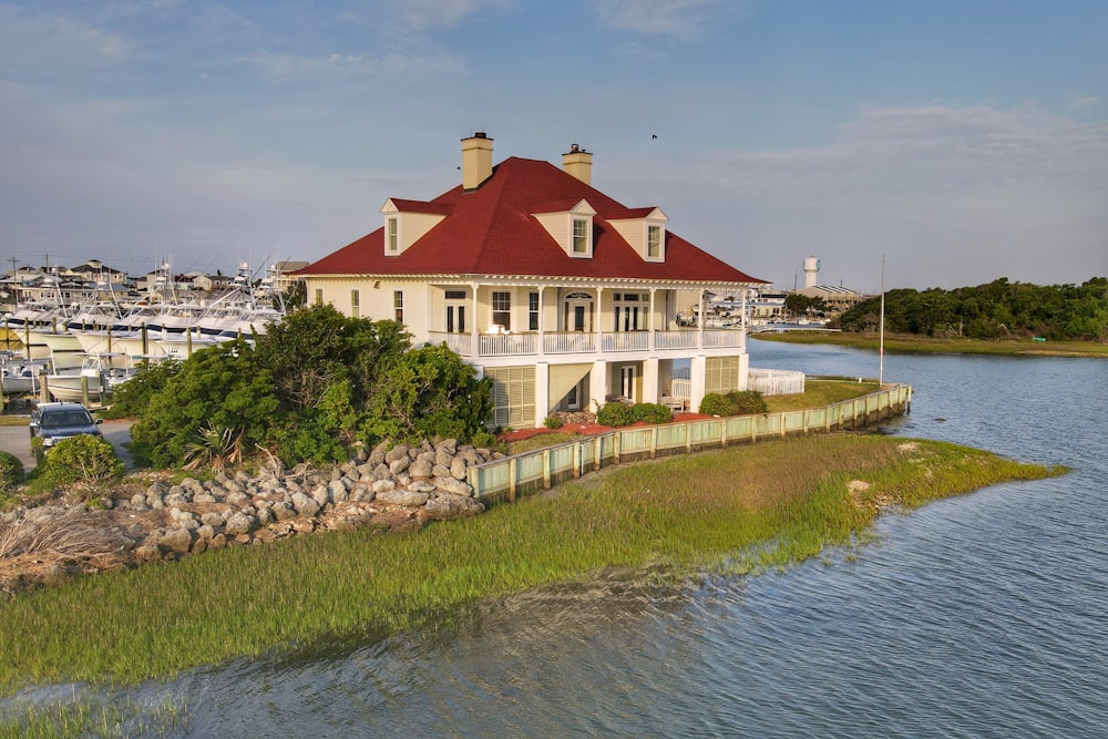 white and red concrete house beside body of water during daytime