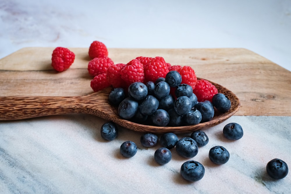 black berries on brown wooden spoon