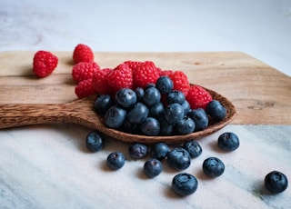 black berries on brown wooden spoon