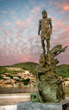 man statue under cloudy sky during daytime