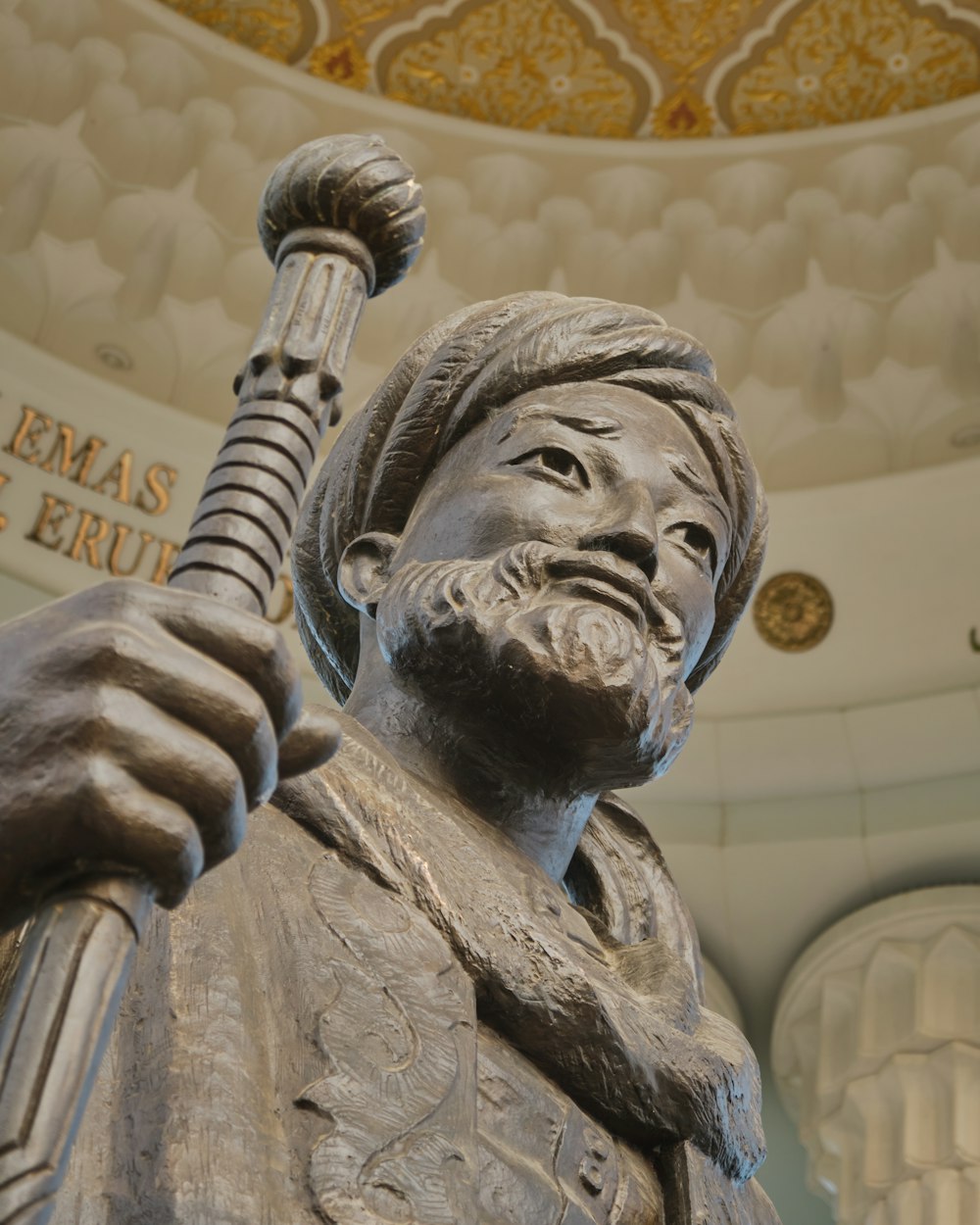 man holding a book statue