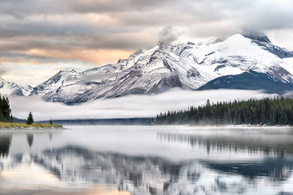 snow covered mountain near lake during daytime