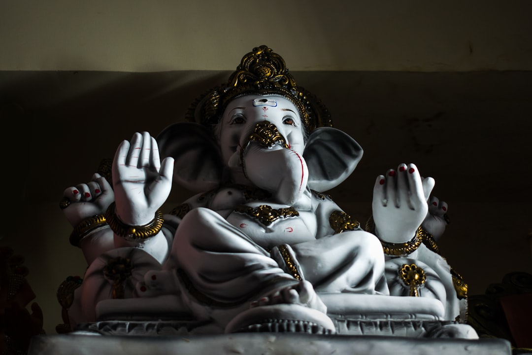 two white ceramic figurines on brown textile