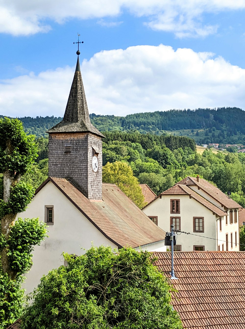 Braunes und weißes Betongebäude in der Nähe grüner Bäume unter weißen Wolken tagsüber