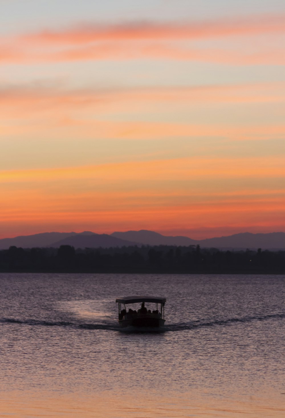 silhouette of boat on sea during sunset