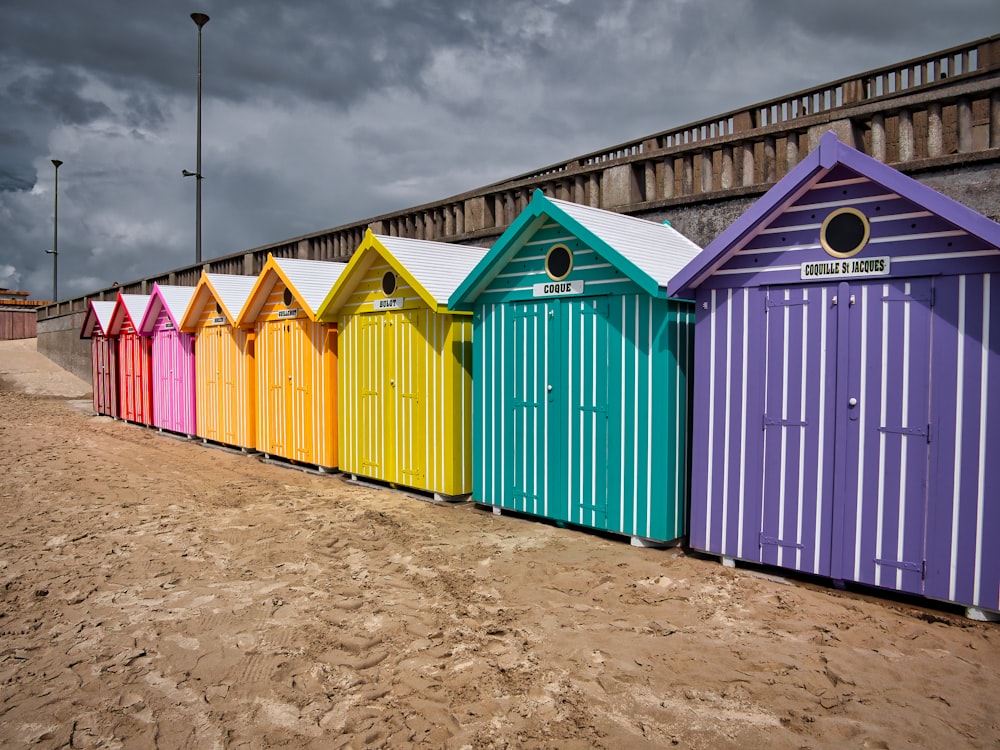 Casas de madera azules, amarillas y verdes bajo nubes grises