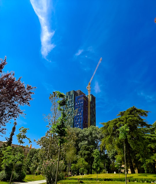 green trees and high rise buildings under blue sky and white clouds during daytime in Tiranë Albania