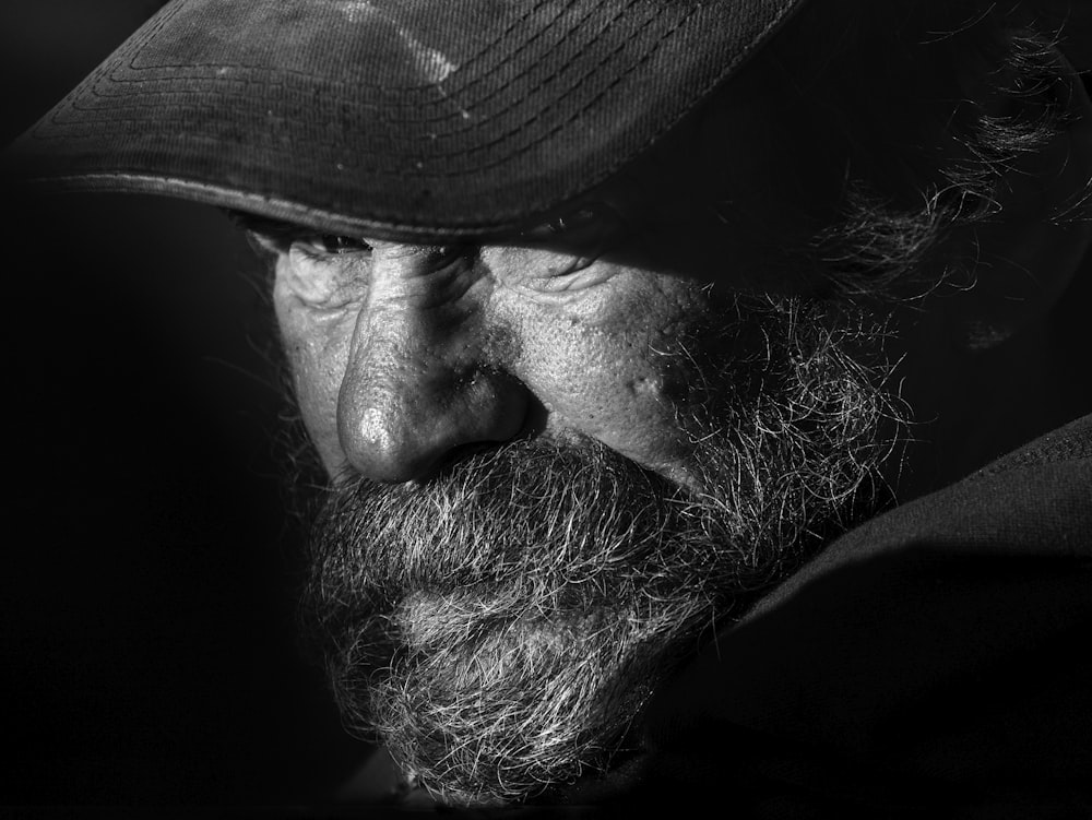 man in black hat in grayscale photography
