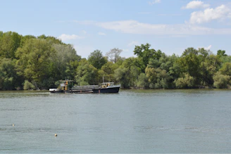 Guests enjoying a serene moment on the vintage-styled luxury barge surrounded by nature.