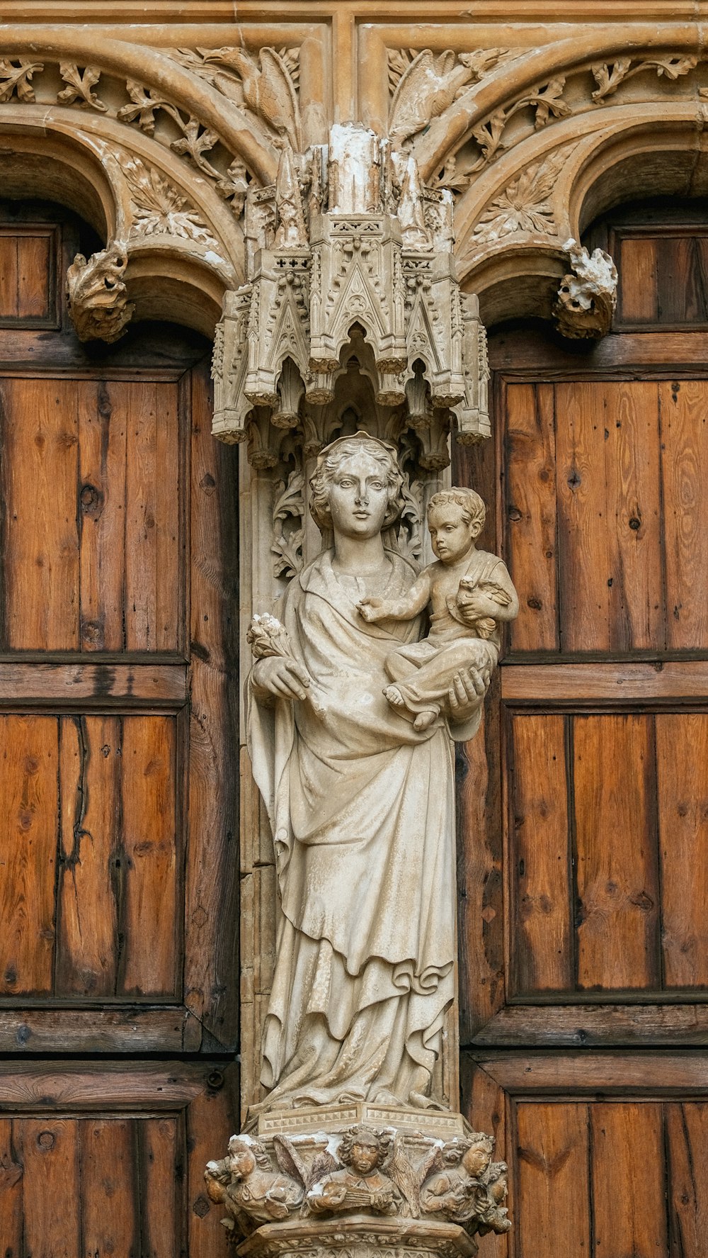 white concrete angel statue on brown wooden door