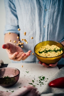person holding yellow ceramic bowl with green liquid