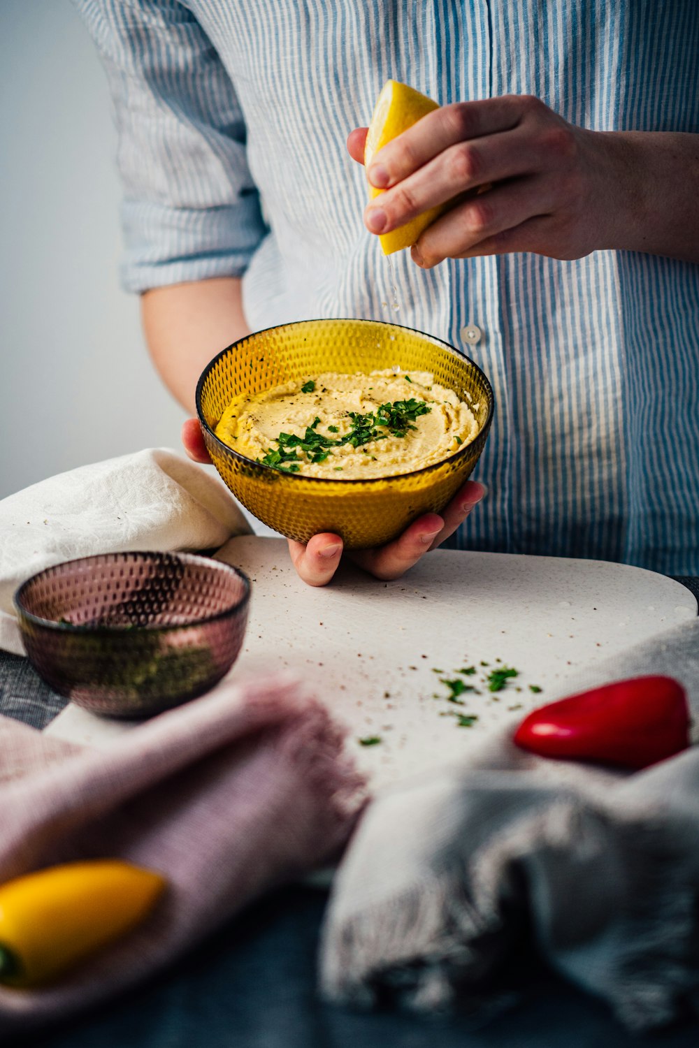 person holding yellow ceramic bowl with green liquid