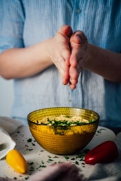 person holding yellow and green ceramic bowl