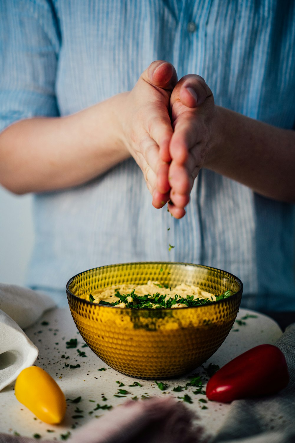 Persona che tiene la ciotola di ceramica gialla e verde