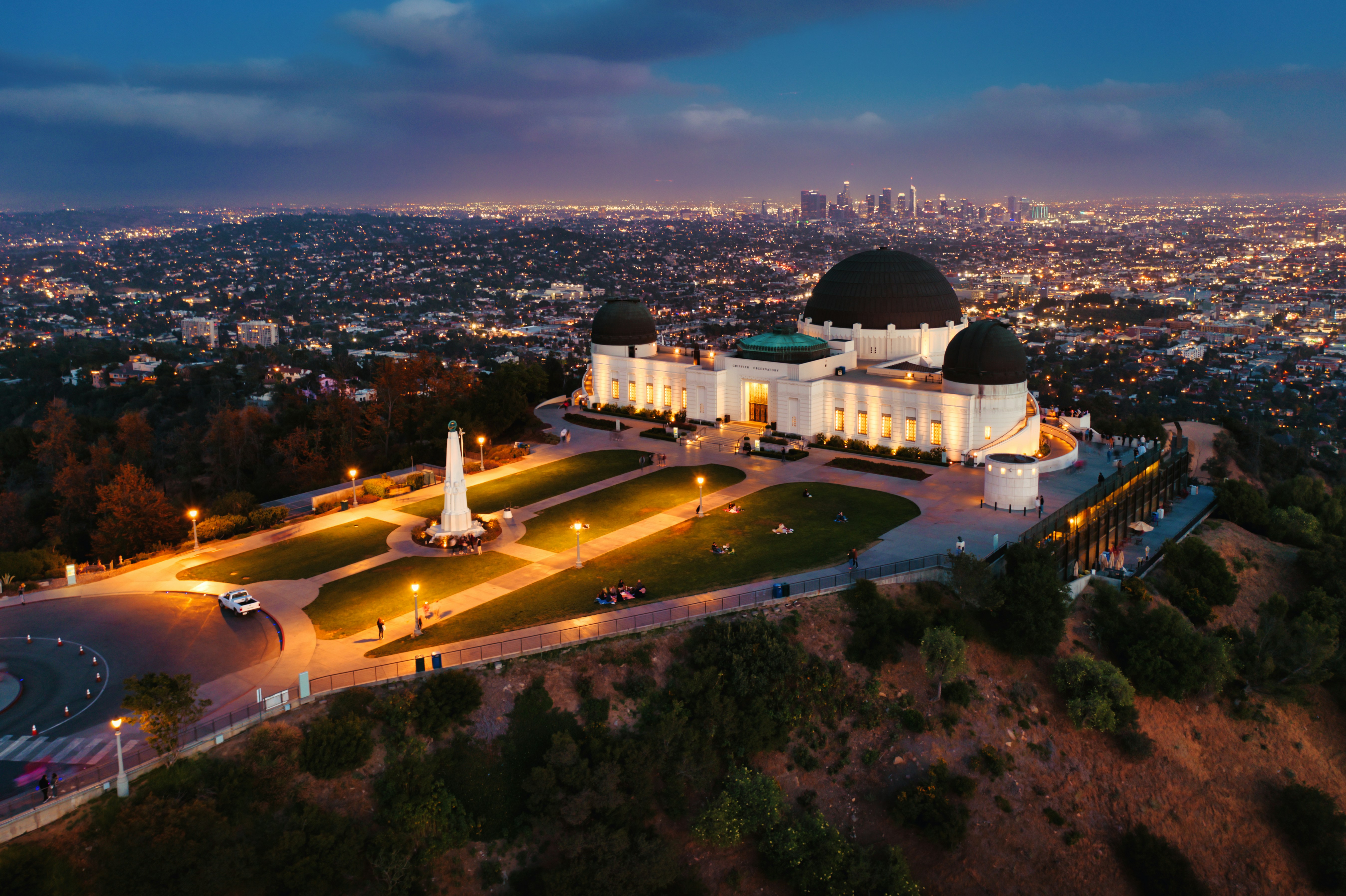 white dome building near green trees during daytime, Griffith Observatory at blue hour aerial shot. 