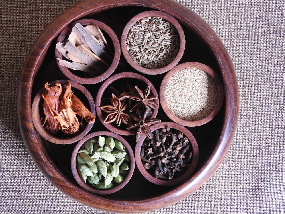 brown wooden round bowl with green and brown leaves