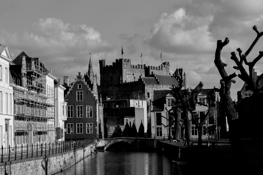 grayscale photo of a river in the middle of a city