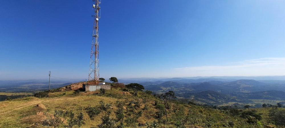 brown electric tower on green grass field under blue sky during daytime