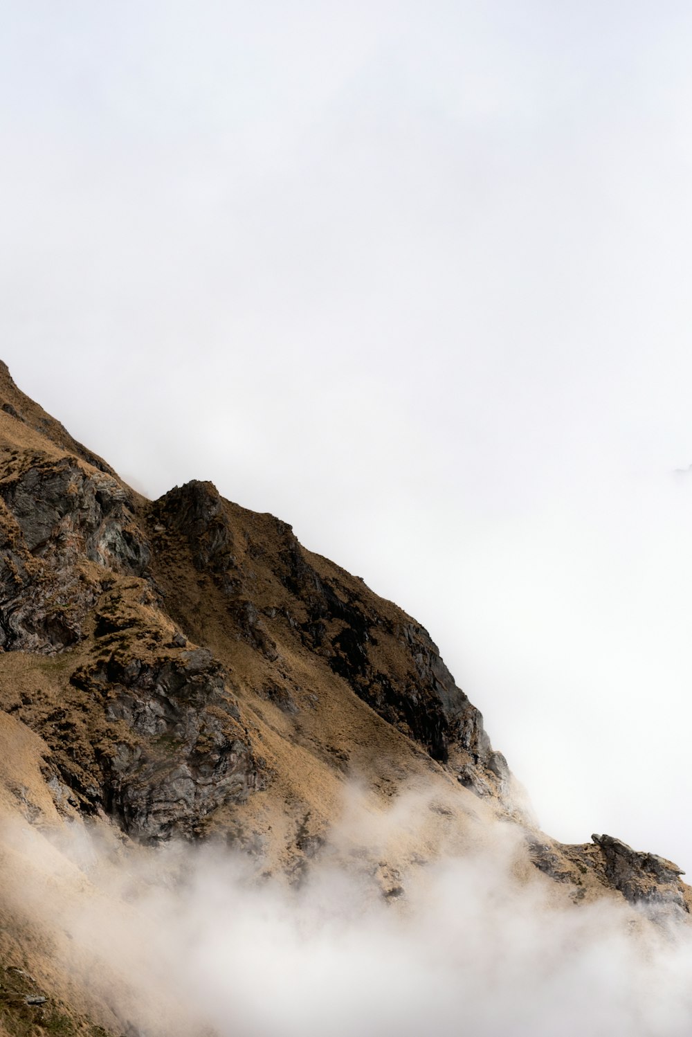 brown rocky mountain under white sky during daytime