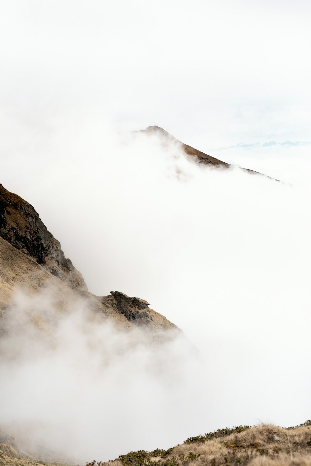 brown mountain covered by white clouds