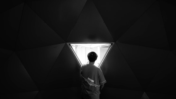 grayscale photo of man in white shirt standing