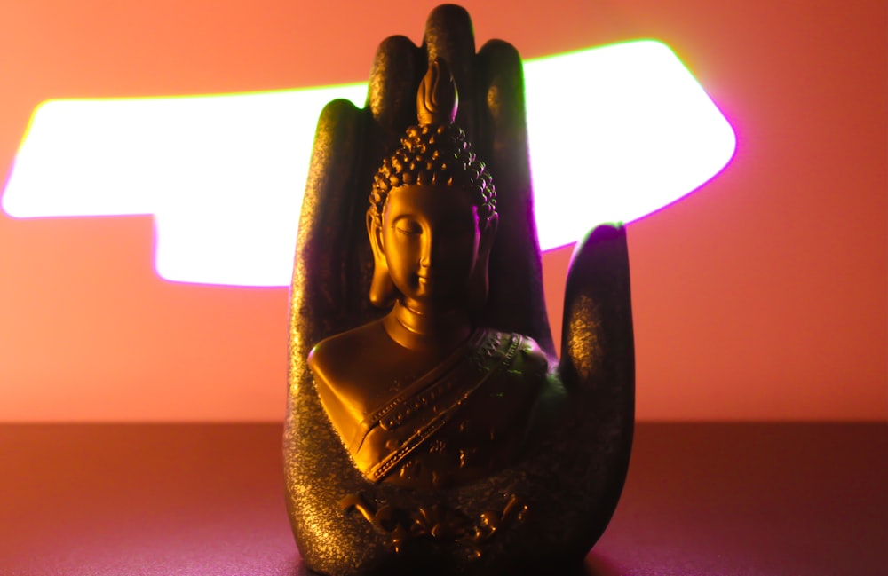 gold buddha figurine on purple table