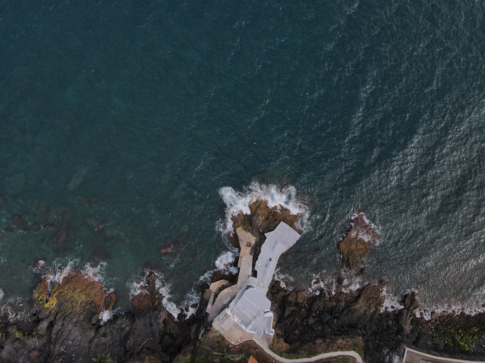 aerial view of white and brown rock formation on body of water during daytime