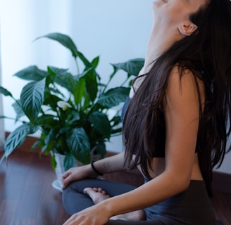 woman in blue tank top and blue denim jeans sitting on white couch