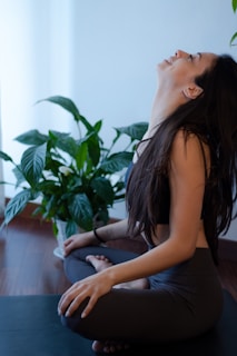 woman in blue tank top and blue denim jeans sitting on white couch