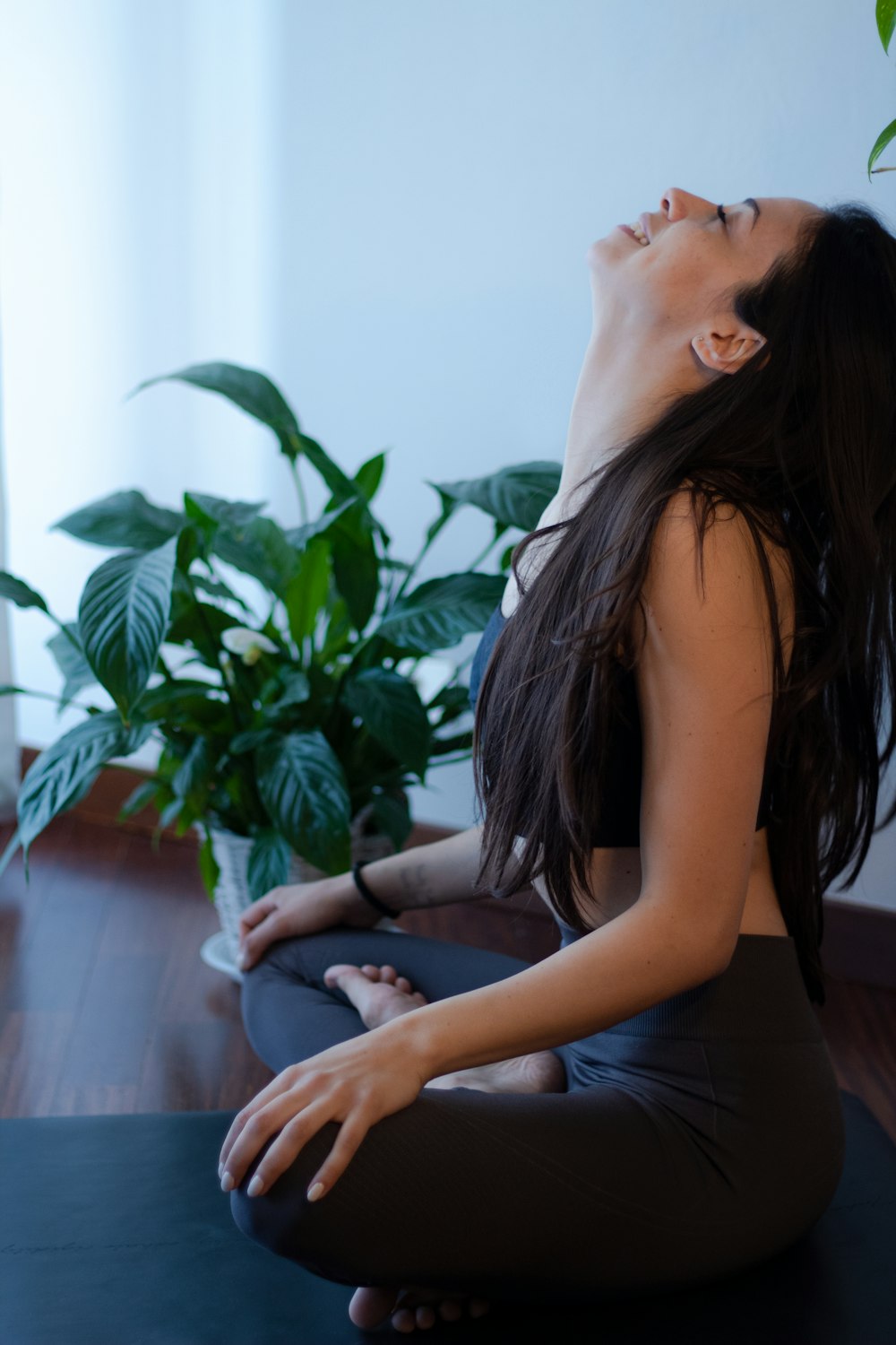 woman in blue tank top and blue denim jeans sitting on white couch