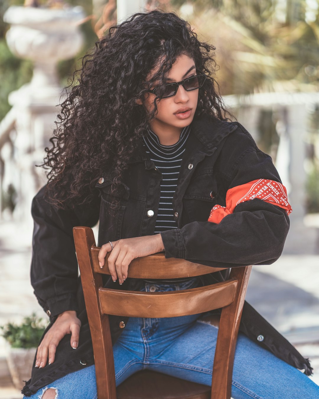 woman in black jacket sitting on brown wooden chair