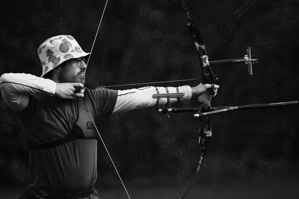 man in black shirt and brown pants holding bow