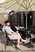An inviting scene of a woman enjoying coffee outdoors, dressed in a comfortable yet stylish casual outfit.