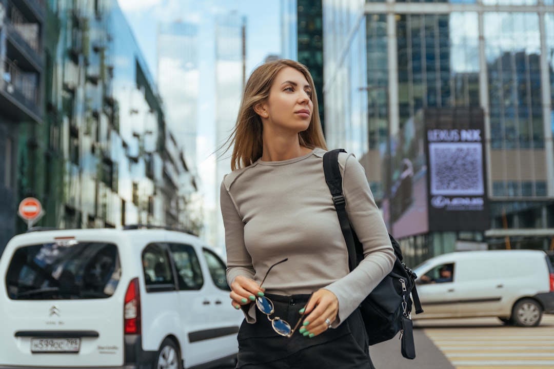 woman in gray long sleeve shirt and black leather sling bag