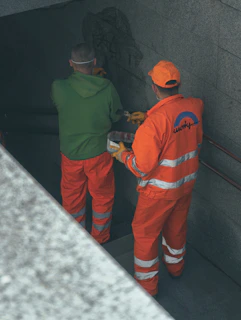 2 men in orange and green jacket