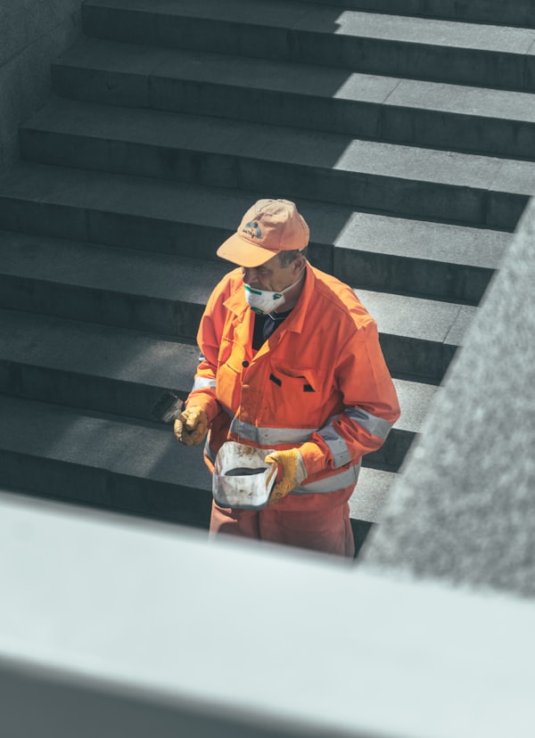 Worker wearing respirator and gloves during industrial cleaning task