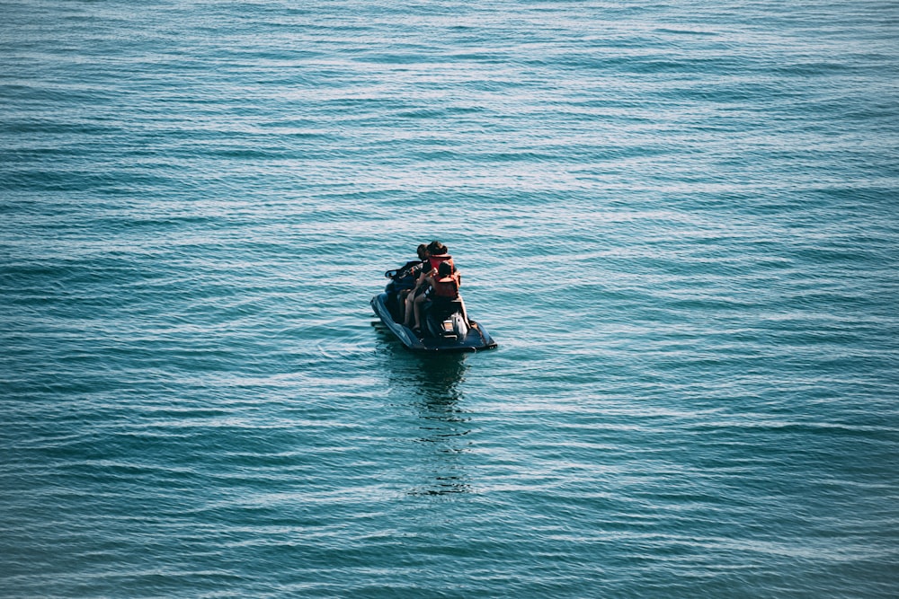 2 people riding on red kayak on body of water during daytime