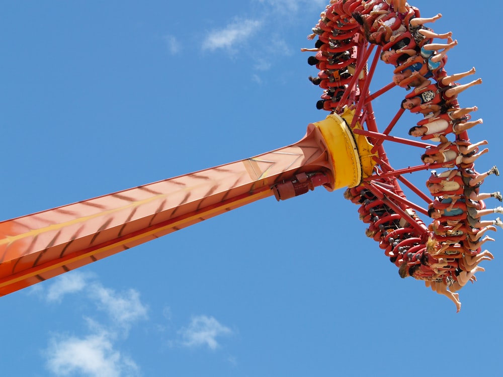 yellow and red roller coaster under blue sky during daytime