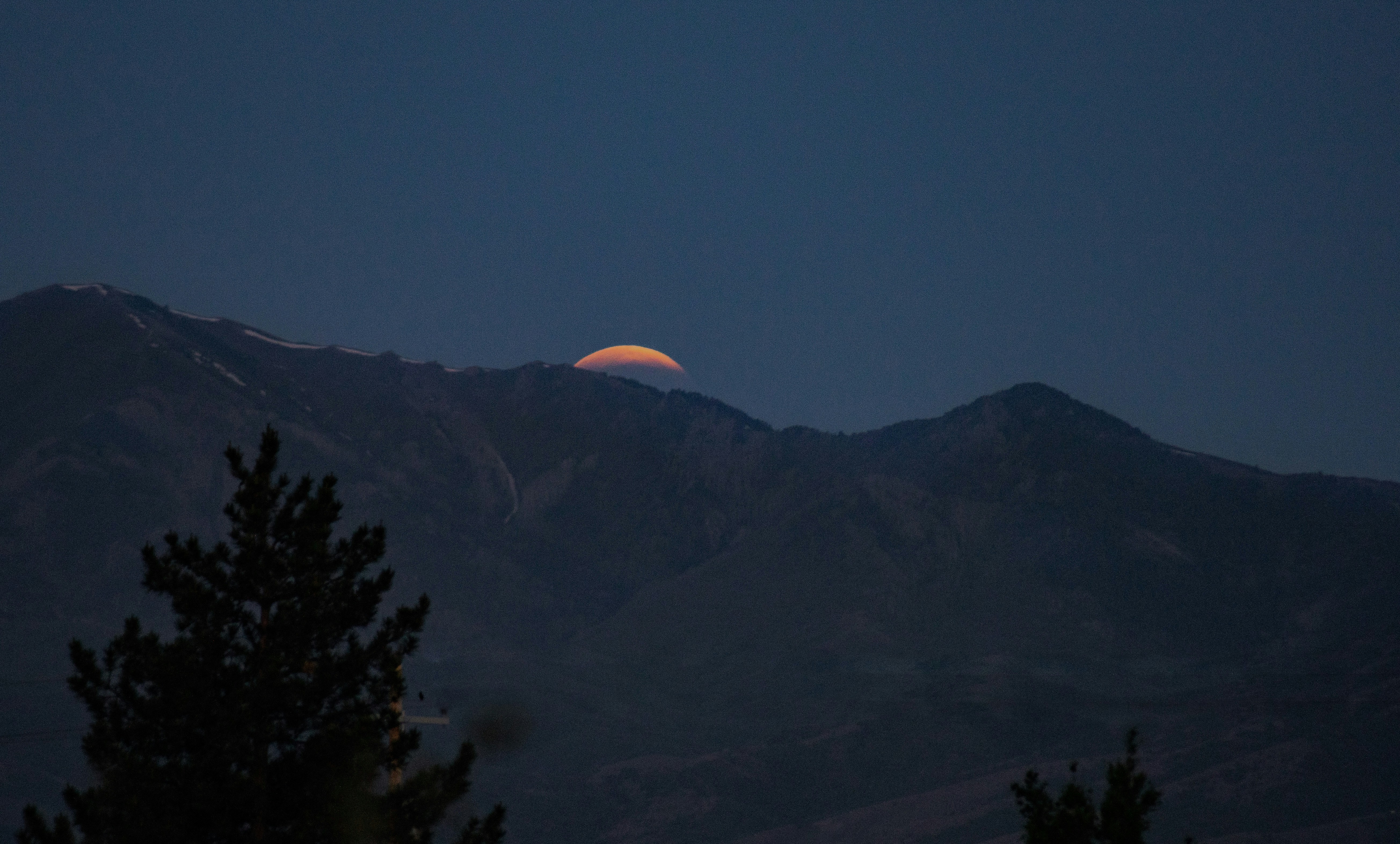 silhouette of trees and mountains during sunset
