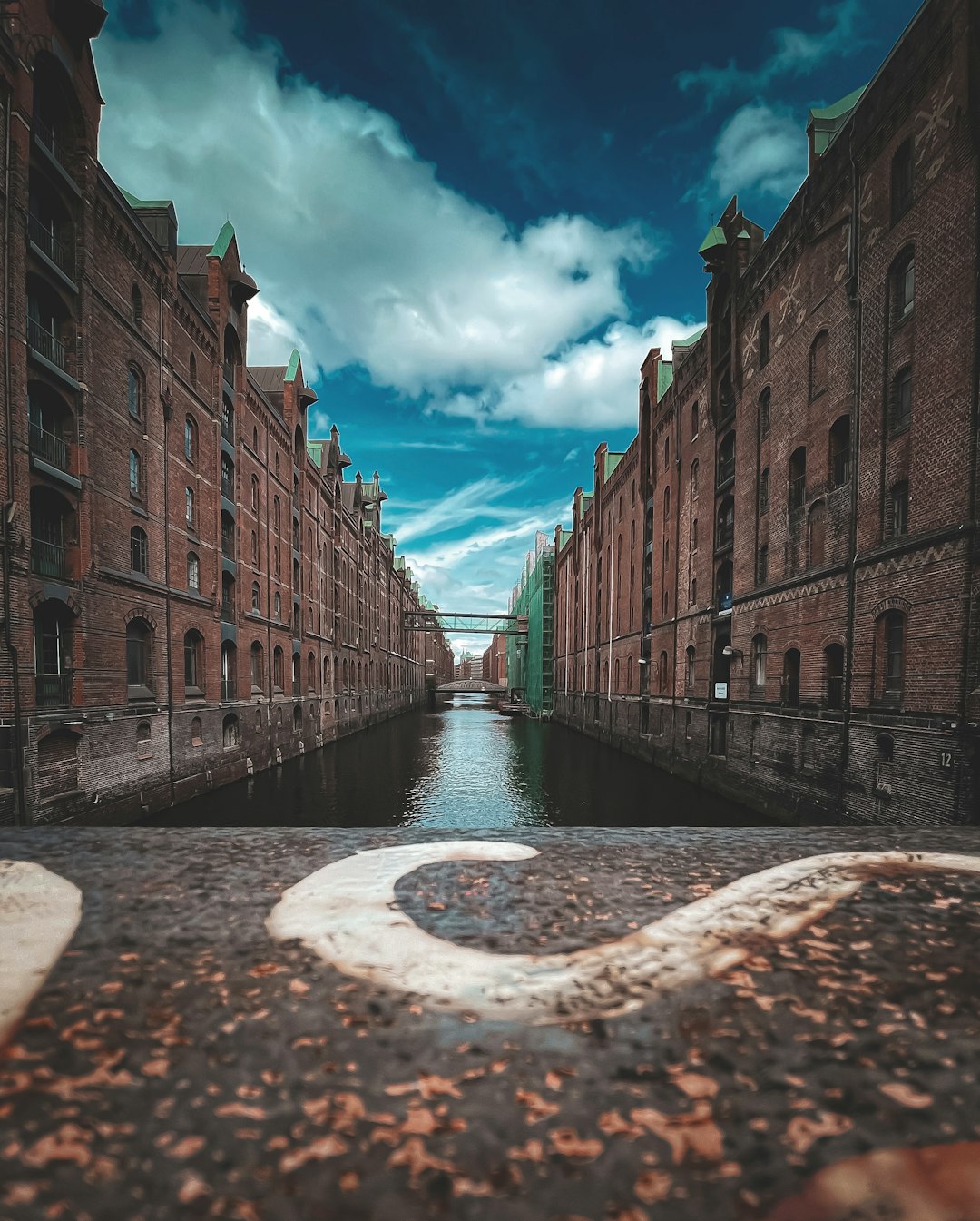 brown brick building near river under blue sky during daytime