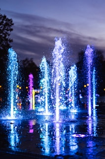 water fountain with lights turned on during night time