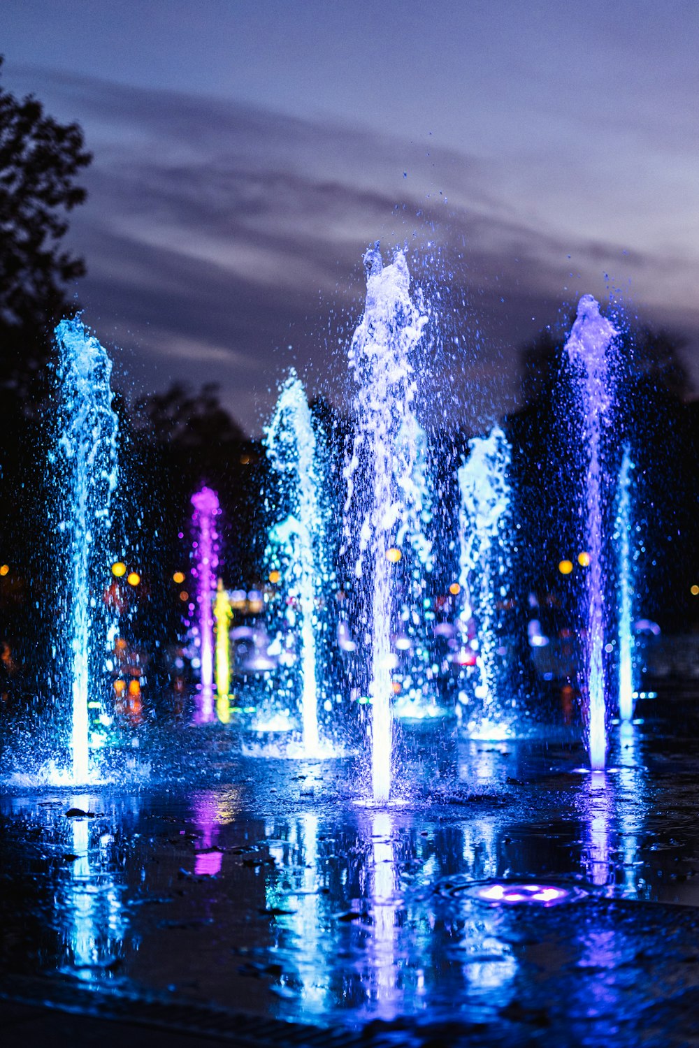 water fountain with lights turned on during night time