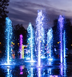 water fountain with lights turned on during night time